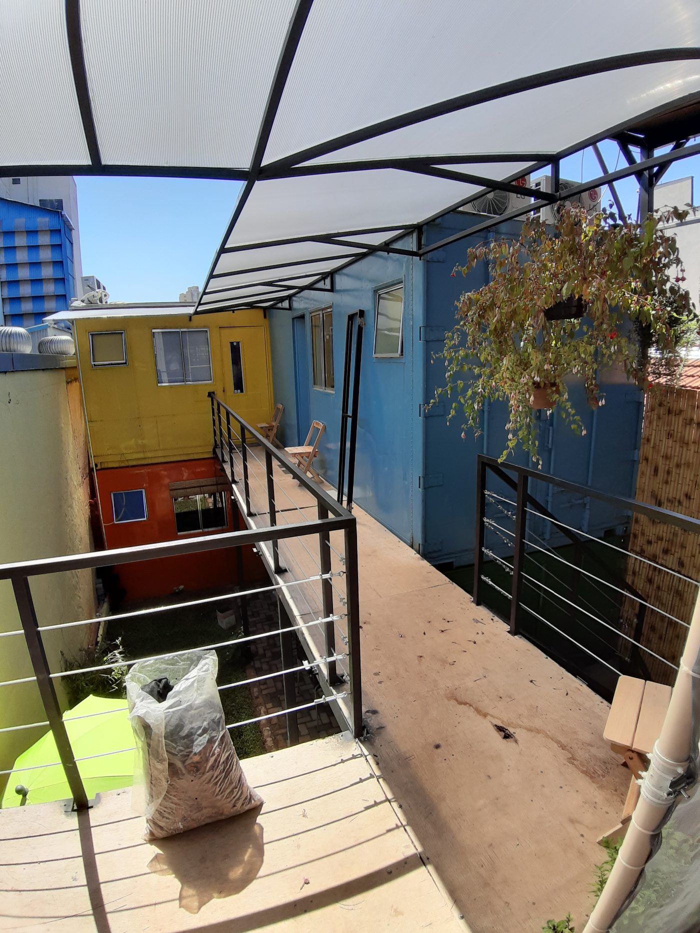 Covered rooftop walkway between the coloured containers