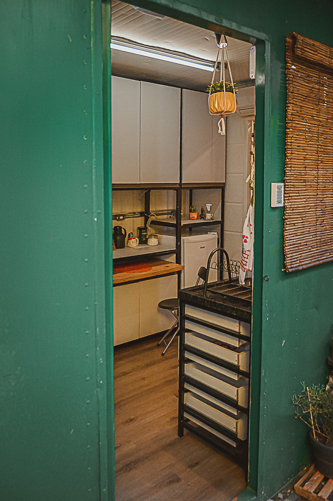 Green container door opening into the cosy kitchen of The Nest